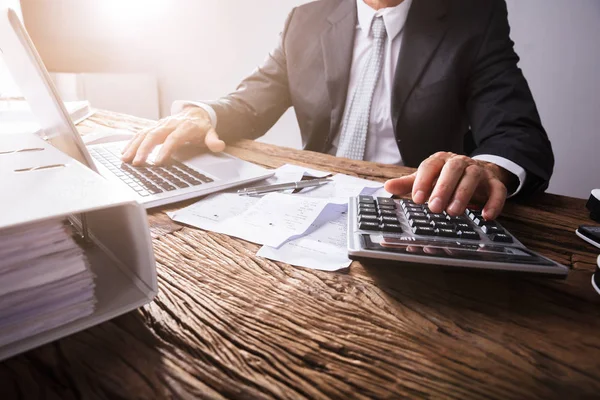 Revisión técnica del IRPF antes de presentar la Renta 2025 Profesional revisando documentación fiscal y realizando cálculos antes de presentar la declaración de la renta 2025